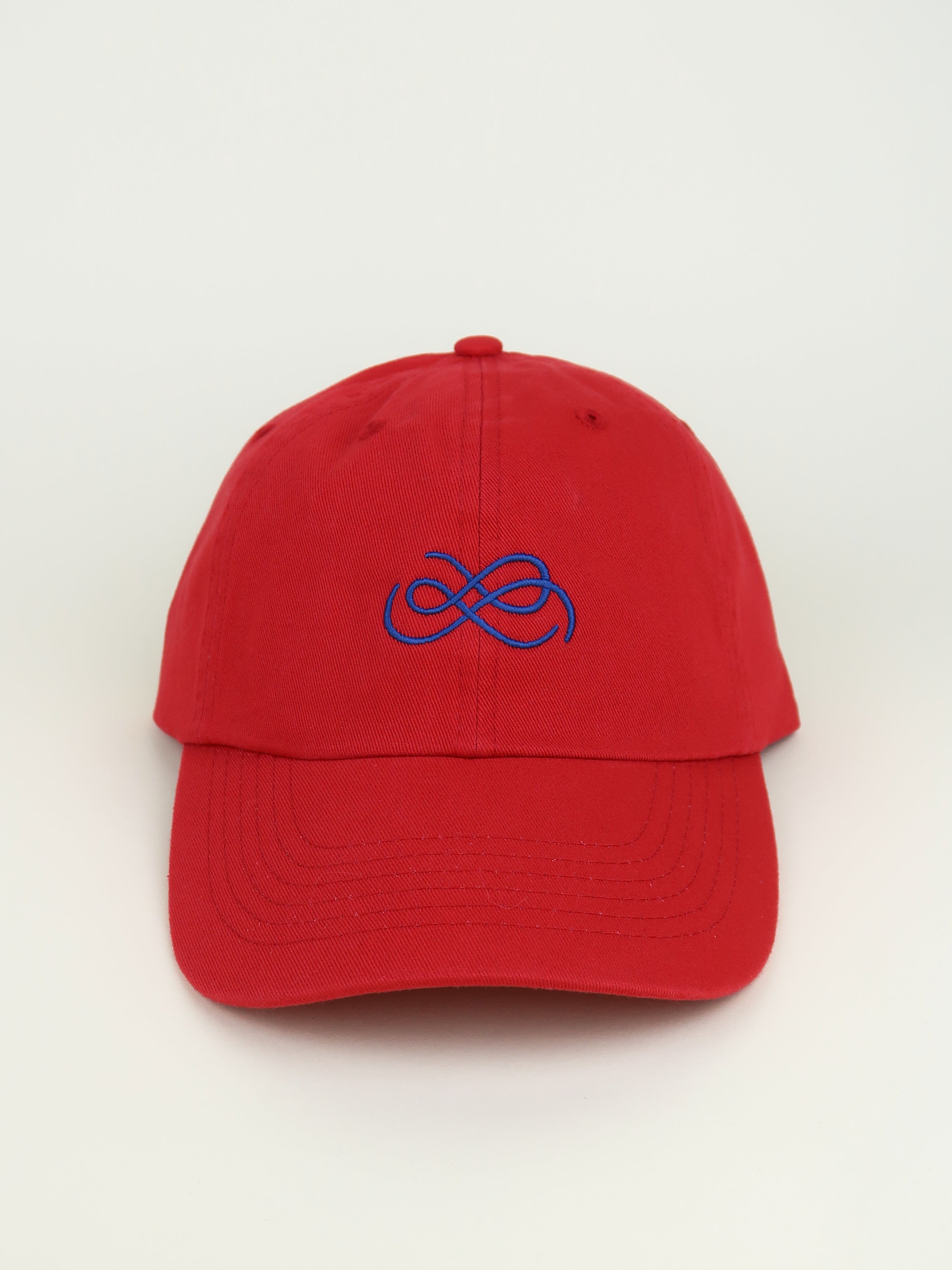 Red cap with blue From Sea To Sol logo on a beige background