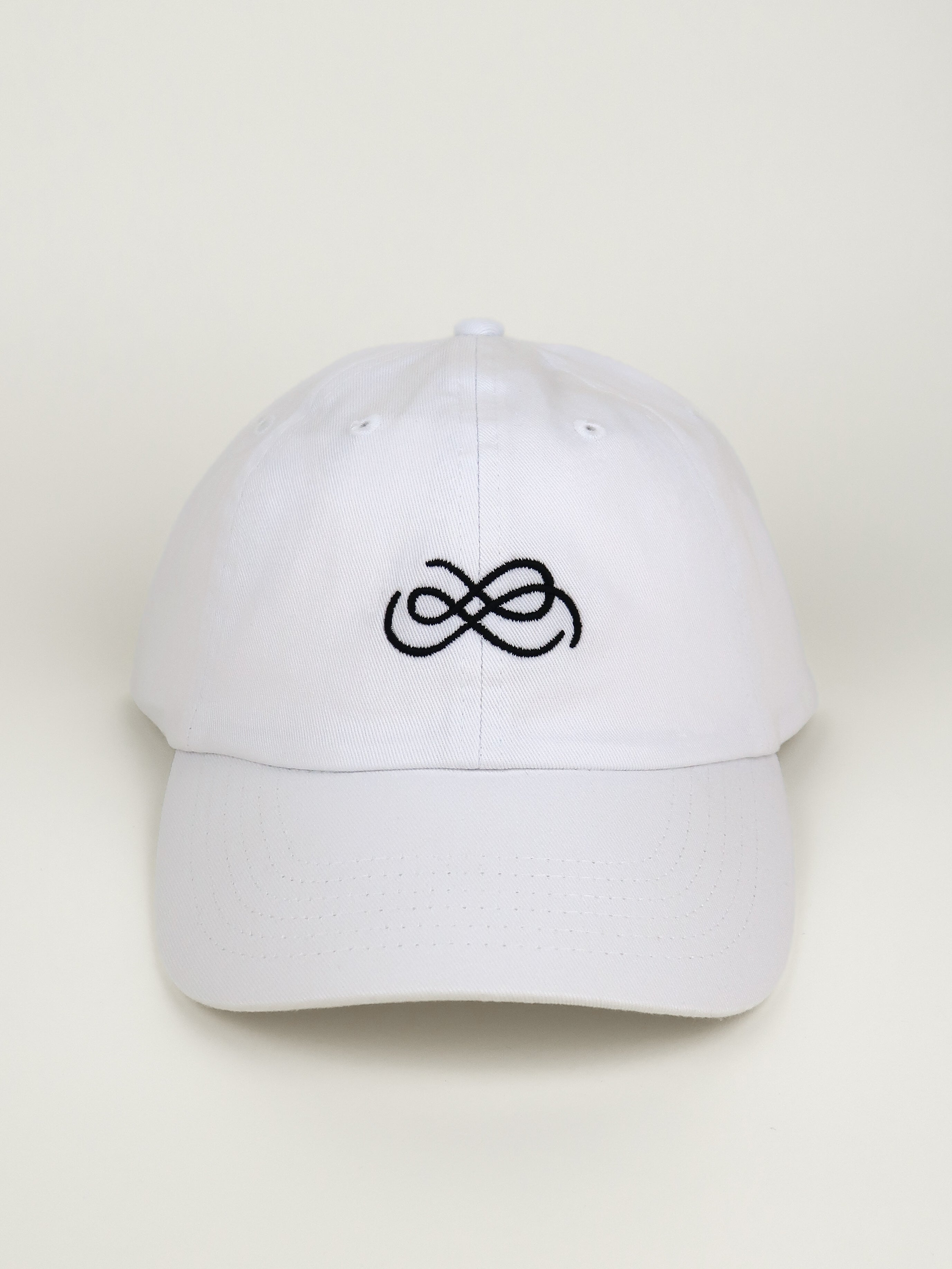 White cap with black From Sea To Sol logo on a beige background