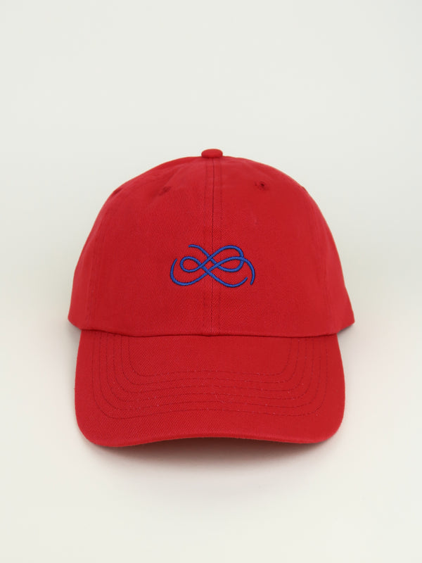 Red cap with blue From Sea To Sol logo on a beige background