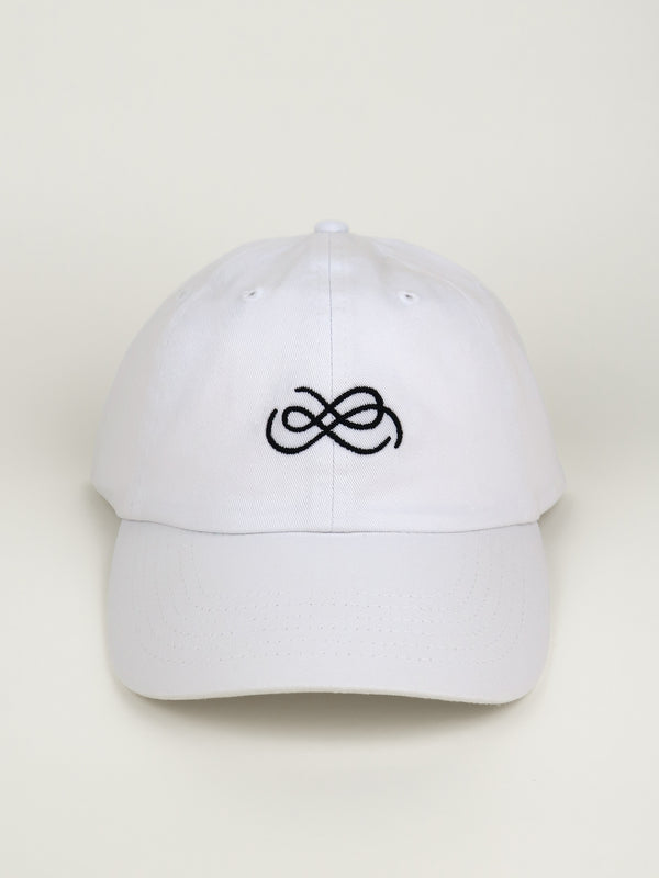 White cap with black From Sea To Sol logo on a beige background